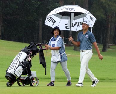 Pouring rain doesn't bother Thai's Gunn Charoenkul and he makes a charge with 65